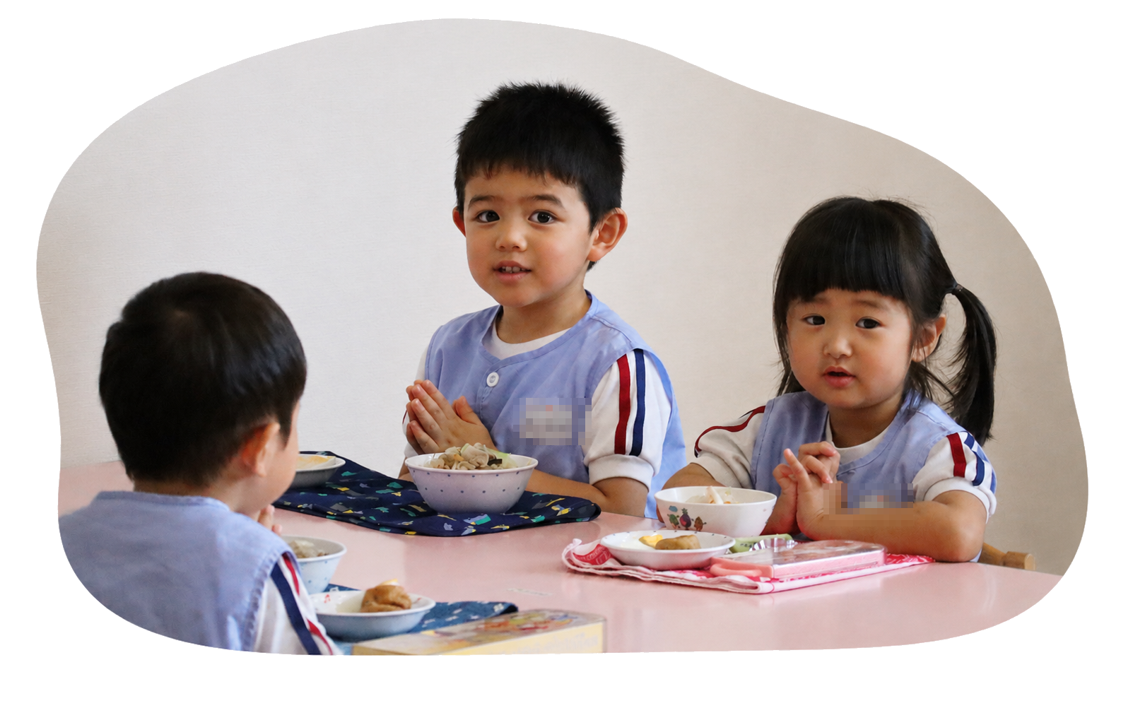 3人の子どもたちが合掌して食事をする様子
