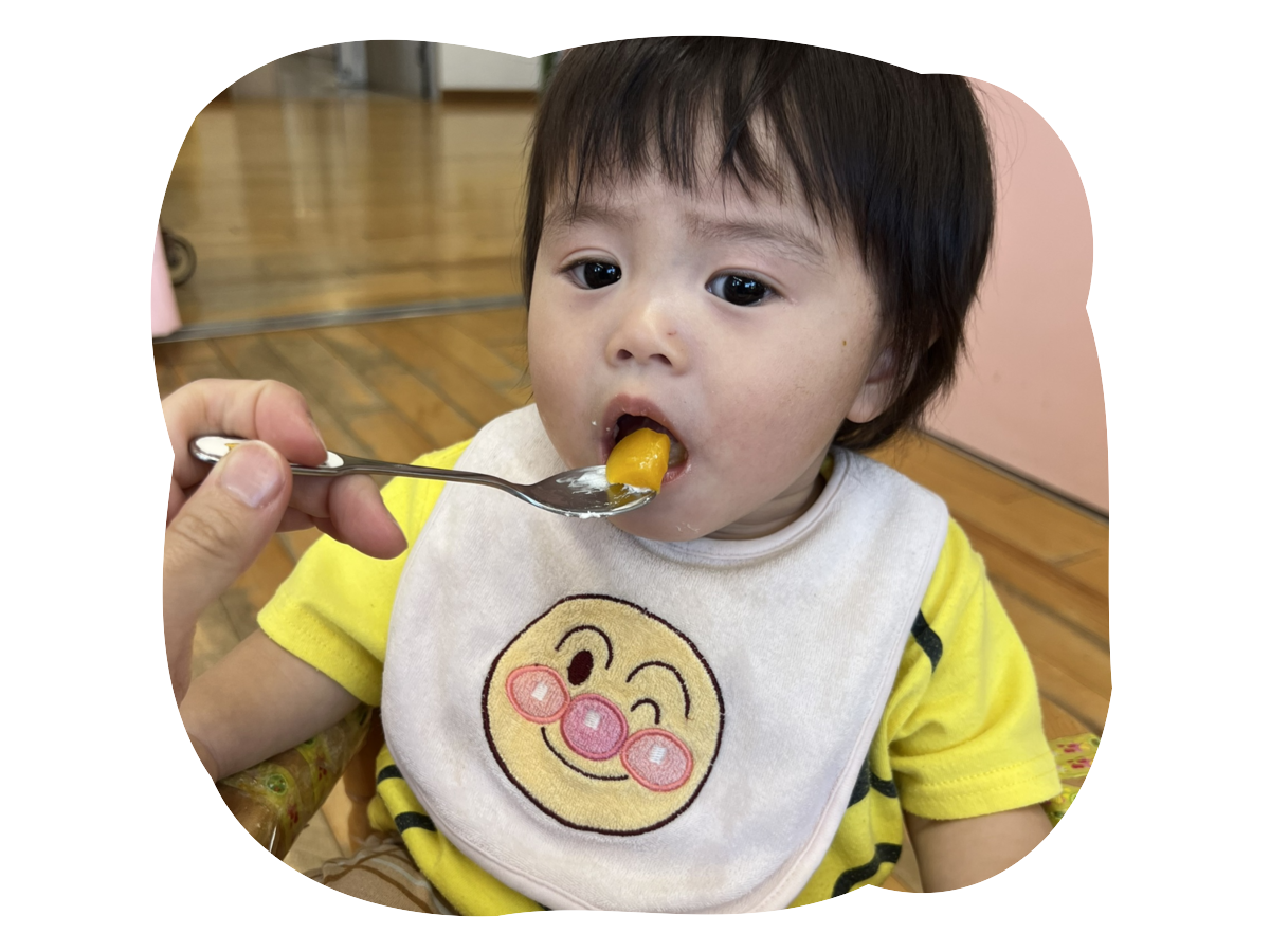 離乳食をスプーンで食べる園児