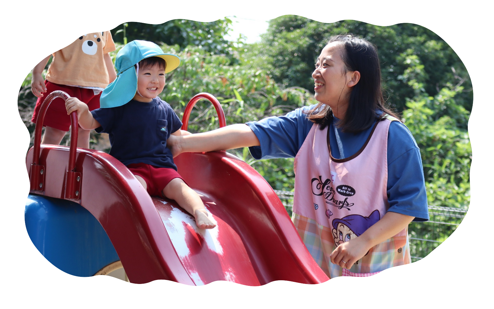 園庭で先生と子どもが遊んでいる様子