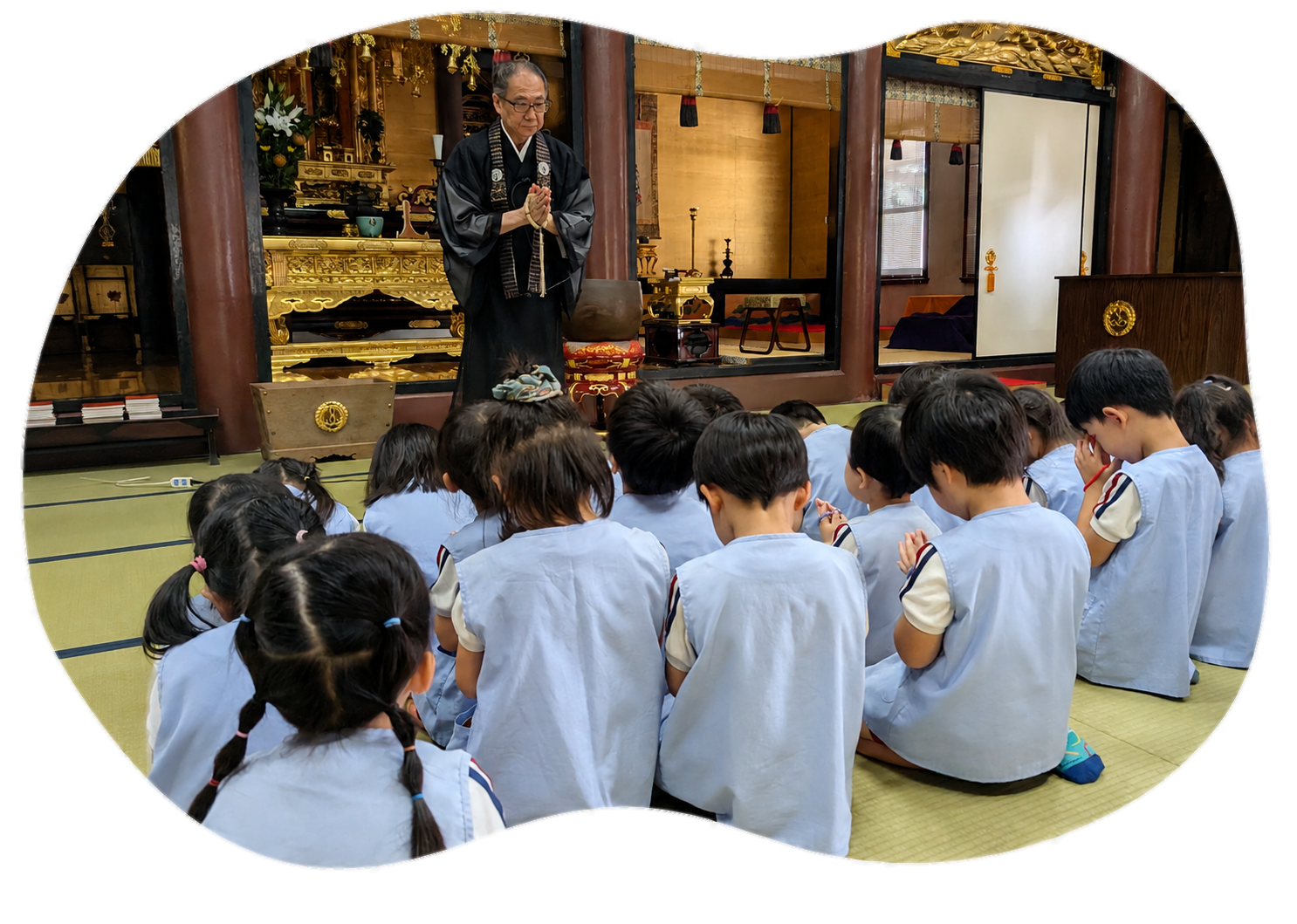 本堂でお参りする園長先生と園児たち