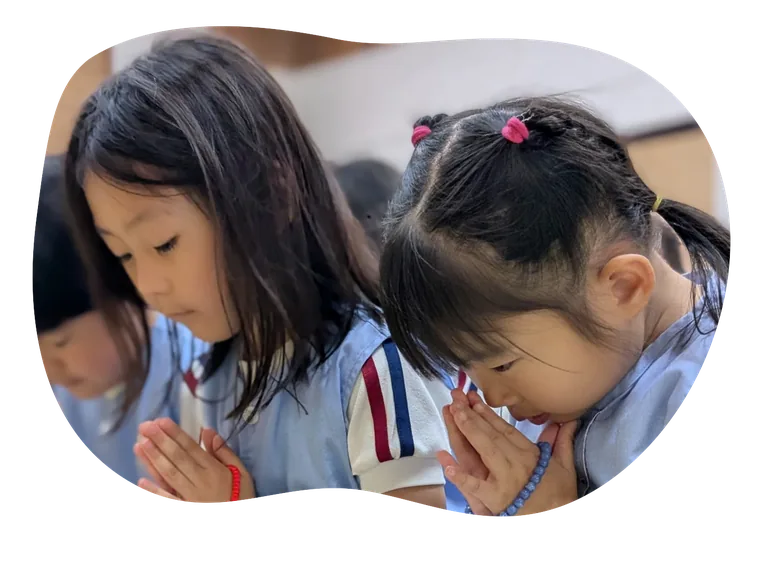 手を合わせる2人の園児