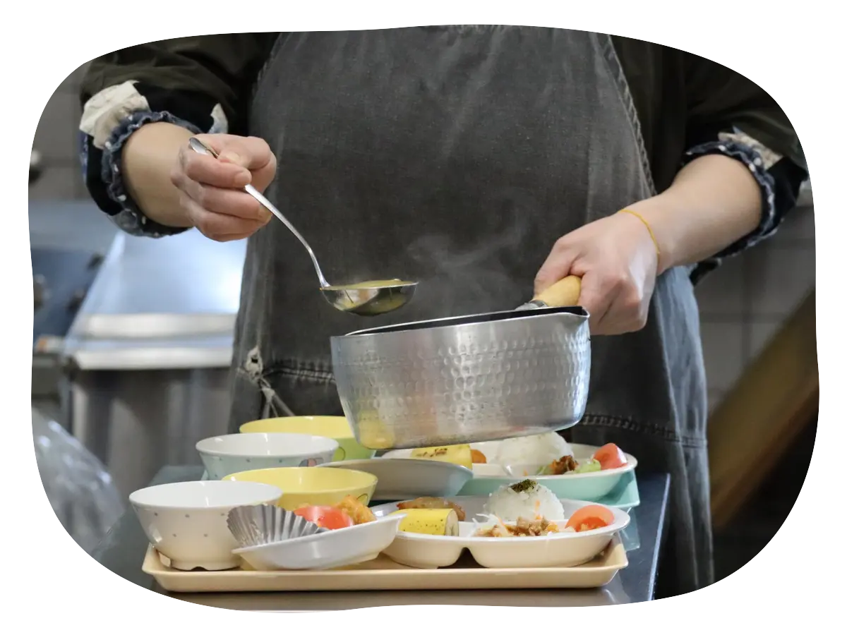 調理員が園児の給食を盛り付けている様子