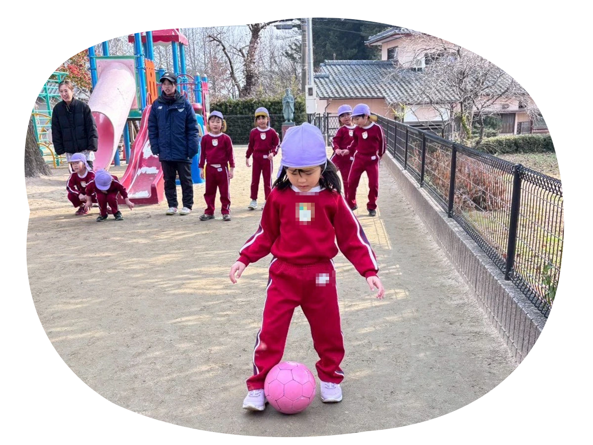 園庭でサッカーをする園児たち