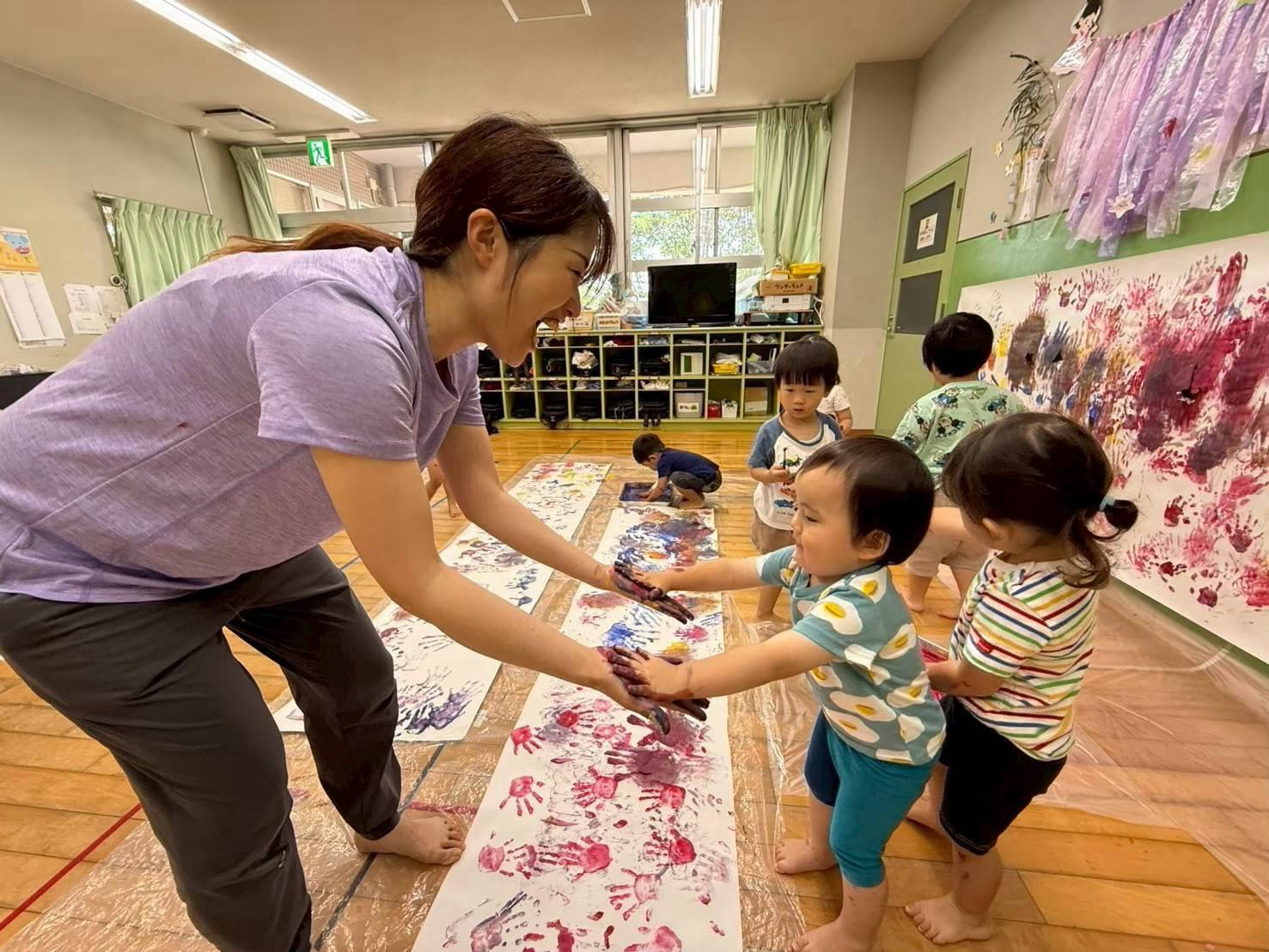 手形アートを楽しむ園児と保育士