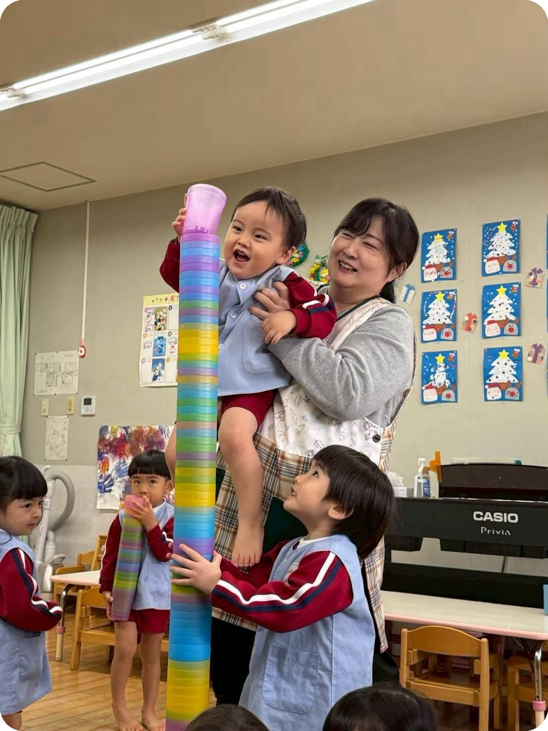 カップを積み上げて遊ぶ子どもと保育士