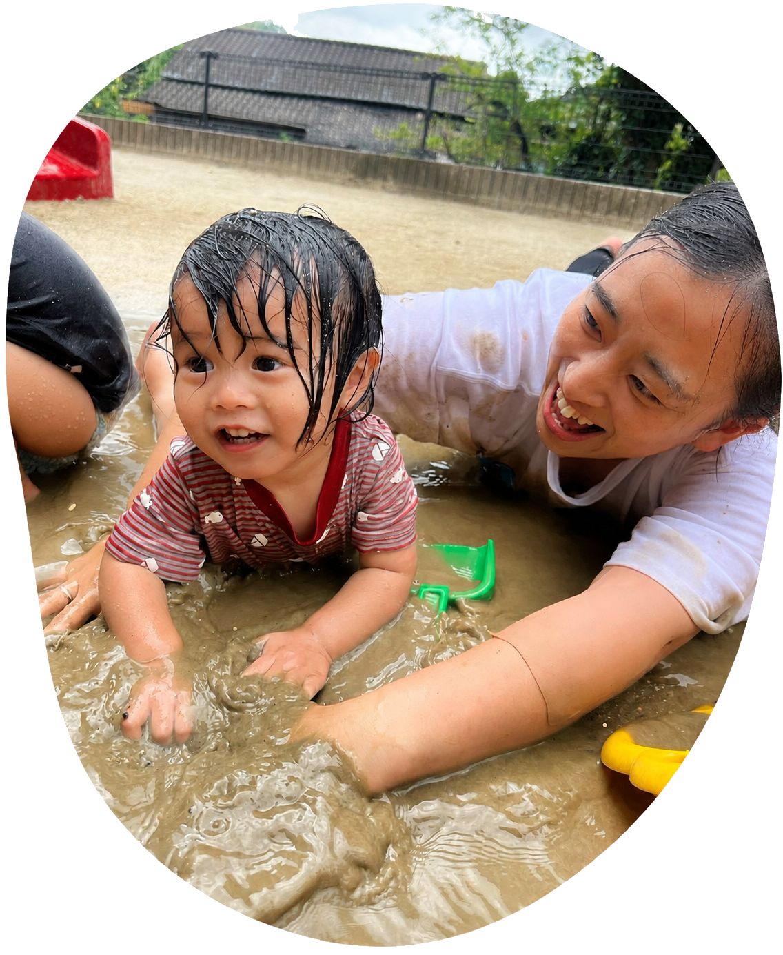 泥んこ遊びをする子どもと保育士